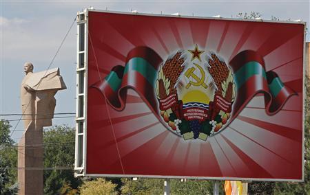 A statue of communist leader Lenin is seen near a poster with the official coat of arms in Tiraspol, in Moldova's self-proclaimed separatist Transdniestria August 31, 2012. REUTERS/Gleb Garanich
